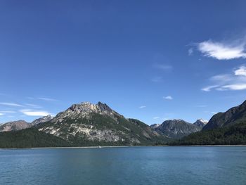 Scenic view of lake and mountains against blue sky