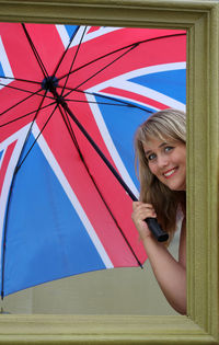 Portrait of happy model holding umbrella