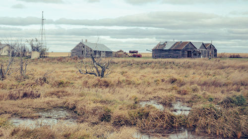 Abandoned house on field against sky