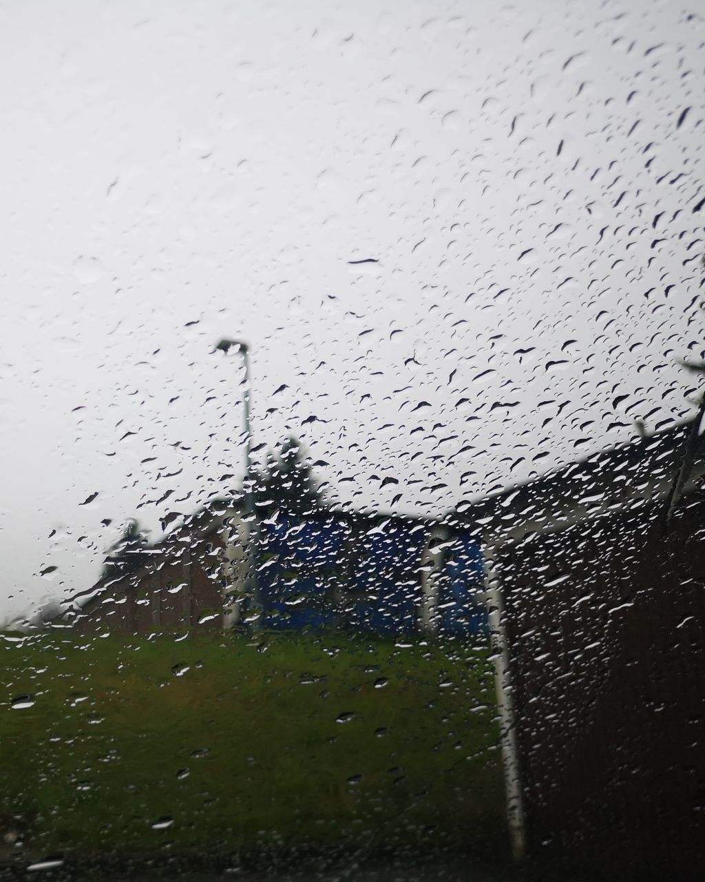 RAINDROPS ON GLASS WINDOW AGAINST SKY