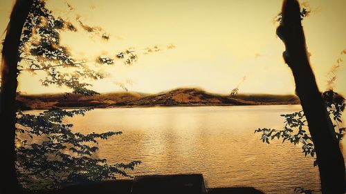 Scenic view of lake against sky at sunset