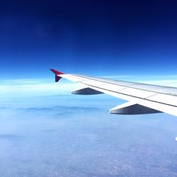 Airplane wing against blue sky