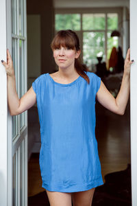 Portrait of woman with bangs standing on doorway