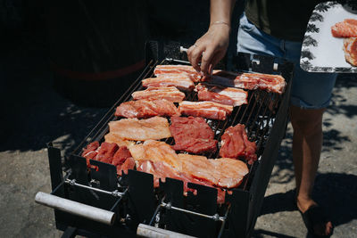 Woman preparing food on barbecue grill