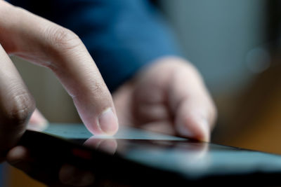 Cropped hand of man using mobile phone