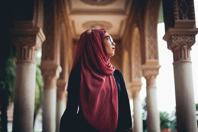 Low angle view of young woman wearing hijab standing in temple