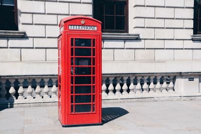 Red telephone booth on footpath