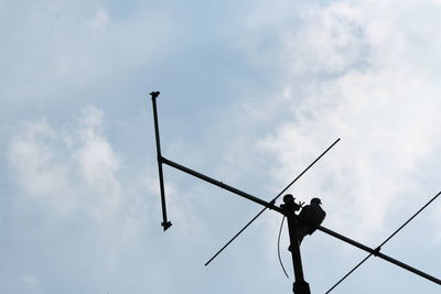 Low angle view of silhouette people against cloudy sky