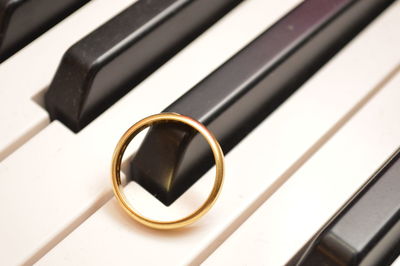 Close-up high angle view of golden ring on piano keys