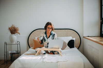 Young girl sitting on bed with laptop