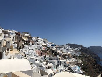 Buildings in town against clear blue sky