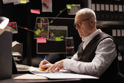 Senior man using mobile phone while sitting on table