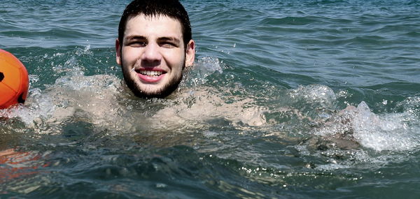 Portrait of smiling man swimming in sea