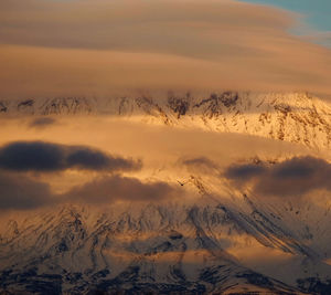 Scenic view of snow covered mountains against sky during sunset