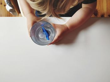 High angle view of girl making face on table