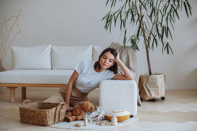 Tired young mother looks at the scattered children's toys