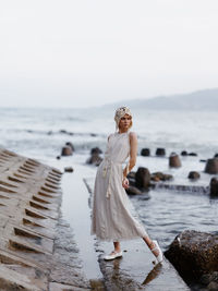 Rear view of woman standing at beach