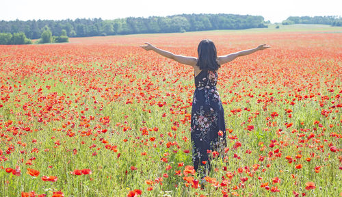 Rear view of woman standing on field