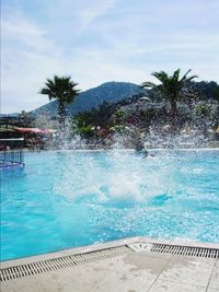 People swimming in pool against sky