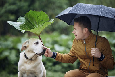 Side view of dog with umbrella