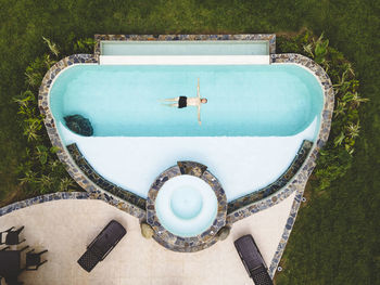 Top view man alone in a swimming pool enjoying a sunny summer day