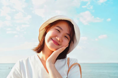 Portrait of smiling woman against sea against sky