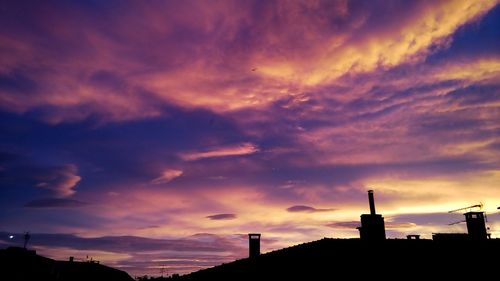 Silhouette of building against dramatic sky