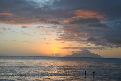 Scenic view of sea against cloudy sky during sunset