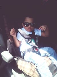 Portrait of young man sitting in sunglasses