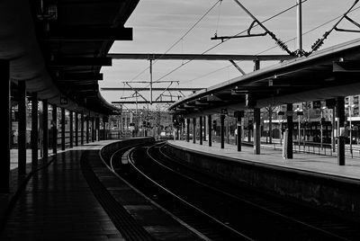 Railroad tracks in city against sky