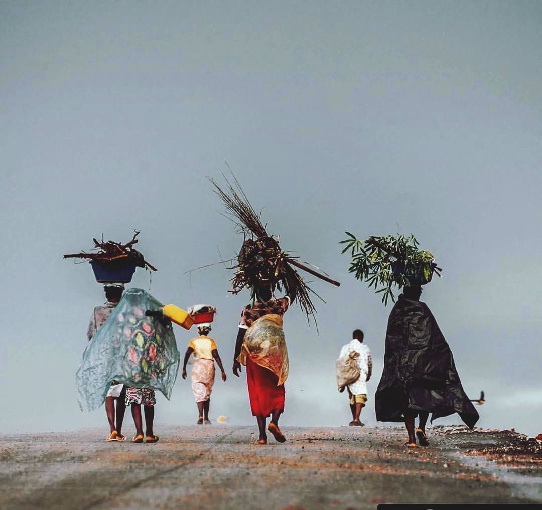 PEOPLE WALKING ON STREET AGAINST SKY