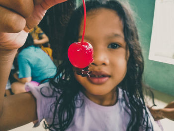 Portrait of cute girl holding cherry