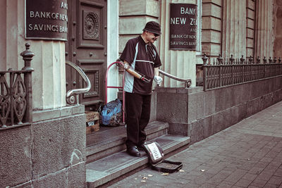 Full length portrait of man standing on footpath