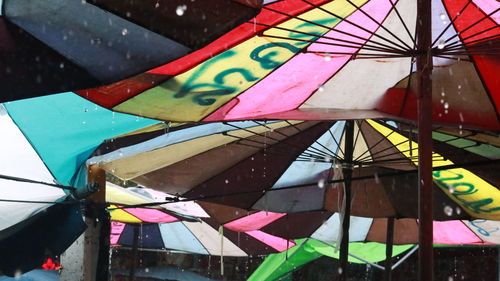 Close-up of multi colored umbrellas hanging in water