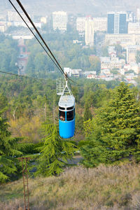 Overhead cable car against trees and mountains