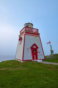 Lighthouse by sea against sky