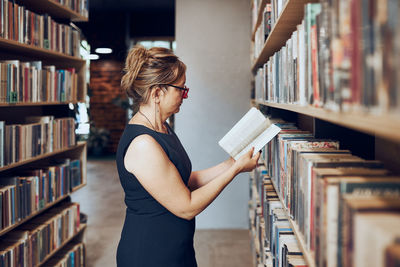 Side view of woman standing in library