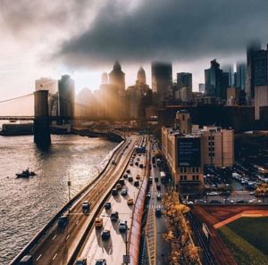High angle view of city buildings against cloudy sky