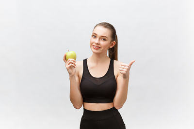 Portrait of a smiling young woman against white background