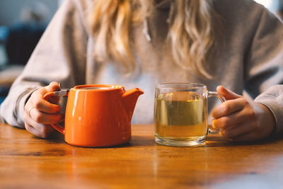 Portrait of a joyful teengirl enjoying a cup of tea at cafe