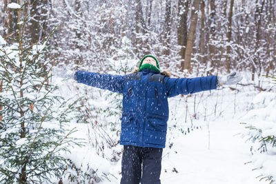 Full length of person standing on snow covered tree