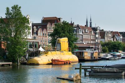 Submarine at riverbank with residential buildings in background