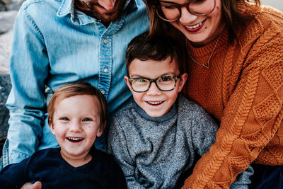 Close up of two happy boys sitting on parents lap