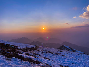 Scenic view of snow covered mountains against sky during sunset captured while trekking. 