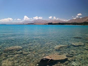 Idyllic shot of lake tekapo and mountains against sky