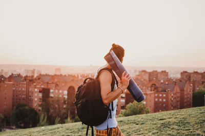 Man photographing with cityscape against sky
