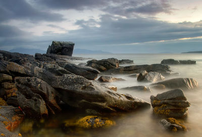 Rocks in sea against sky