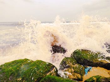 Scenic view of sea waves splashing on rocks