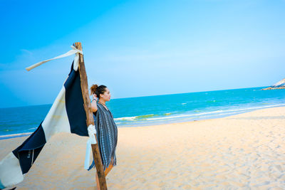 Woman on beach against blue sky