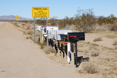 View of signboard in sign board against blue sky